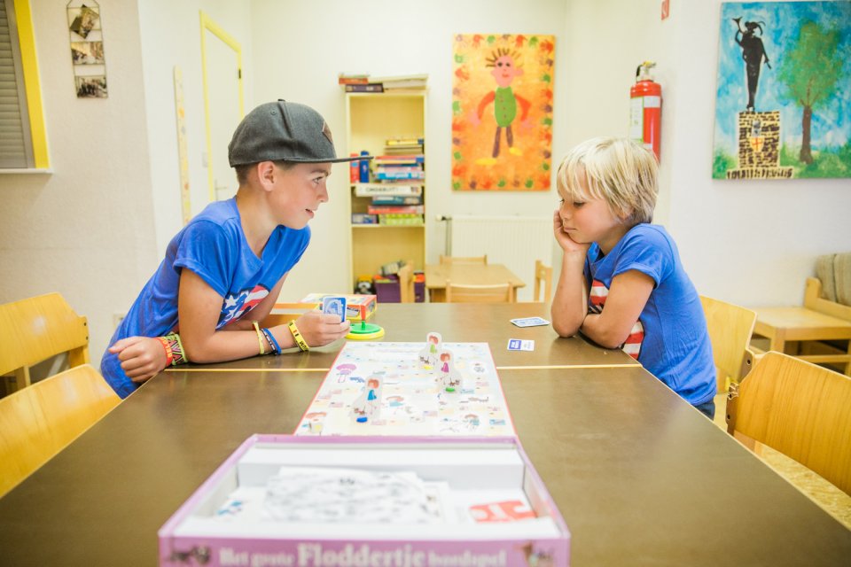 Twee kinderen spelen een spel in de gemeenschappelijke zithoek